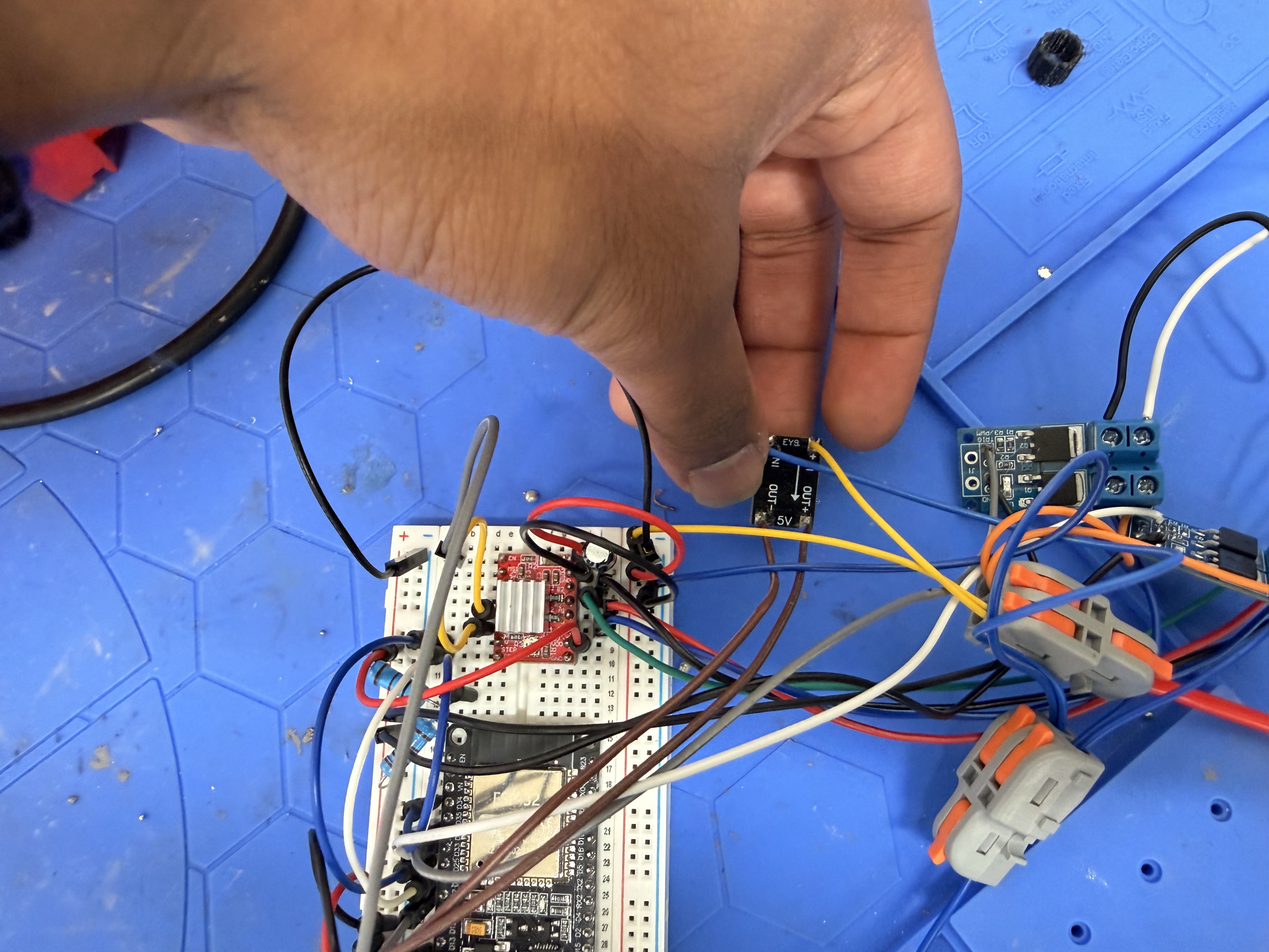 Buck converter module held above ESP32 breadboard